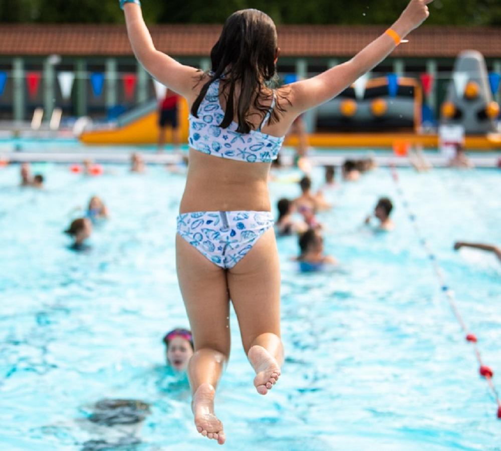 A girl jumps into the pool at The National Lido of Wales, Lido Ponty