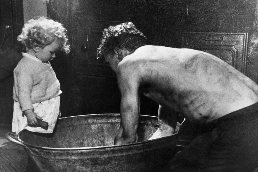Miner washes in tin bath, which gave Railway Terrace the name Tub Alley. Cwmparc Pathway of Hope